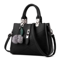 Black pebbled leather handbag with V-shaped stitching and plush fur ball pendant charm - 29x13x21cm / Black