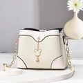 Minimalist beige bucket bag with pleated texture and rabbit chain charm on long strap - White