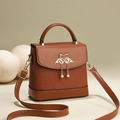 Brown faux leather crossbody bag with vertical textures and golden swan heart clasp - Brown