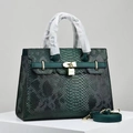 Detailed close-up of dark green snakeskin textured handbag with golden padlock and strap - Green