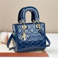Navy blue patent leather quilted handbag with gold metal charms and crossbody strap - Blue