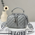 Grey quilted crossbody bag with bear pendant and sporty logo strap on geometric display - Gray