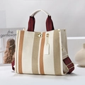 Retro striped canvas tote bag with leather trim and gold twist lock in lifestyle setting - Large / White and Yellow