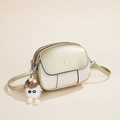 Beige en gouden lederen crossbodytas met monster pluche hanger en een slanke schouderriem - Champagne