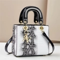 Elegante Handtasche mit schwarz-weißem Tiermuster, Goldbeschlägen und einem Schultergurt - Nagelmuster Weiß