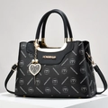 Schwarze Monogramm-Handtasche mit Herz-Perlenanhänger und Griff auf weißem Display - Schwarz