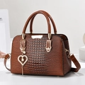 Bolso de mano marrón con textura de cocodrilo, colgante de corazón y correa - Amarillo Tierra