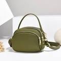 Olive green nylon crossbody bag with triple zipper layers and gold hardware on white pedestal - Green/Nylon