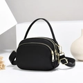 Three-layer black nylon crossbody bag with gold hardware on white pedestal - Black/Nylon