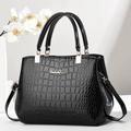 Elegante bolso negro con relieve de cocodrilo, logo metálico y asas dobles pulidas - Negro