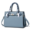 Elegante hellblaue strukturierte Handtasche mit Goldschloss und dekorativem Seidentuch - Himmelblau