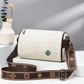 White crocodile pattern cylinder bag with brown wide floral strap on a white pedestal - White