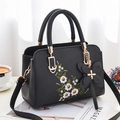 Black embroidered faux leather tote bag with floral patterns and butterfly charm accessory - Black