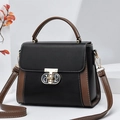 Classic two-tone crossbody Boston bag with gold buckle on white geometric display - Black