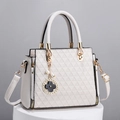 White quilted crossbody handbag with gold hardware and a clover charm on a display stand - Off White