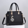 Elegant black geometric embossed handbag with gold hardware and pearl floral pendant charm - Black