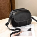 Minimalist black pebble leather crossbody bag featuring contrasting white stitching and double zippers - Black