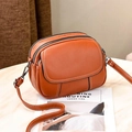 Orange lychee grain leather crossbody bag with multiple zippers and white contrast stitching - Orange