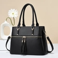 Black pebbled leather tote bag with gold zippers, tassels and adjustable shoulder strap - Black