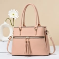 Pink orange pebbled leather tote bag with dual tassels and gold hardware accents - Pink