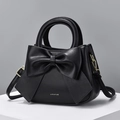 Black matte leather crossbody bag with a large decorative bow and top handle - Black