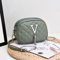 Deep green quilted crossbody bag featuring a silver metal V logo and triple zip compartments - Green