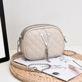 Beige quilted crossbody bag with silver V-letter and tassels on a woven mat - Off-white