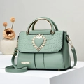 Elegante borsa a mano verde menta goffrata coccodrillo con fibbia a cuore dorata su supporto - Verde