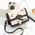 Cream crossbody bag with European travel illustrations and black ribbon detail - Black