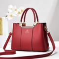 Elegant red leather tote bag with gold hardware and adjustable strap on a minimalist stand - Burgundy