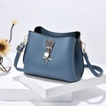 Bolso saco de cuero azul oscuro con herrajes dorados y colgante de oso en podio blanco - Azul