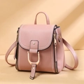 Detail of pink faux leather backpack featuring golden horseshoe buckle and white stitching - Pink