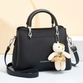Black leather handbag with silver hardware and a cute bear charm pendant accessory - Black
