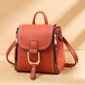 Detail der rotbraunen Kunstledertasche mit Kontrastnähten und goldenen Metallschnallen - Orange