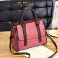 Deep pink leather handbag with dark brown handles and shoulder strap on a wooden table - Dark Pink