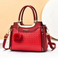 Red woven leather tote bag with gold circular handles and miumiu logo on a minimalist background - Red