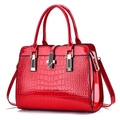 Sac à main en cuir verni rouge avec gaufrage crocodile et détails en métal doré - Rouge