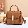 Caramel brown pebbled leather handbag with golden twist lock and adjustable shoulder strap - Earthy Yellow
