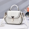 Elegant white quilted shoulder bag with gold hardware and iconic character clasp detail - White