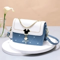 Blue and white heart-stitched crossbody bag with Mickey-shaped lock on a display stand - Blue & Beige