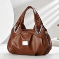 Brown soft leather handbag with pleated details and silver hardware in a modern studio setting - Brown