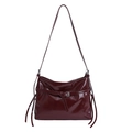 Glossy burgundy PU leather tote bag with silver buckle and tassel details on white background - Angola Red
