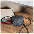 Detail van zwart geweven mini crossbodytas voor kinderen op een rustieke houten tafel - Zwart