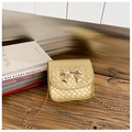 Détail d'un mini sac tissé or champagne avec nœud rose doré et bandoulière chaîne - Doré