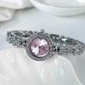 Gros plan d'une montre bracelet argentée sertie de strass avec cadran violet sur plateau - Cadran Rose Argenté
