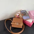 Detalle del mini bolso cuadrado en cuero caramelo con acentos de hebillas plateadas - Marrón