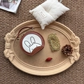 Detail view of mini rabbit crossbody bag with golden chain strap on a warm tray - Tan