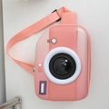 Detail of pink camera-shaped hardshell kids chest bag showing lens deco and strap - Orange Pink