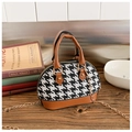 Close-up of houndstooth shell bag with brown leather trim and golden chain strap - Brown
