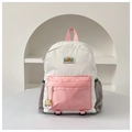 Detail view of a color-block school backpack with triple compartments and a medal charm - Large / Pink